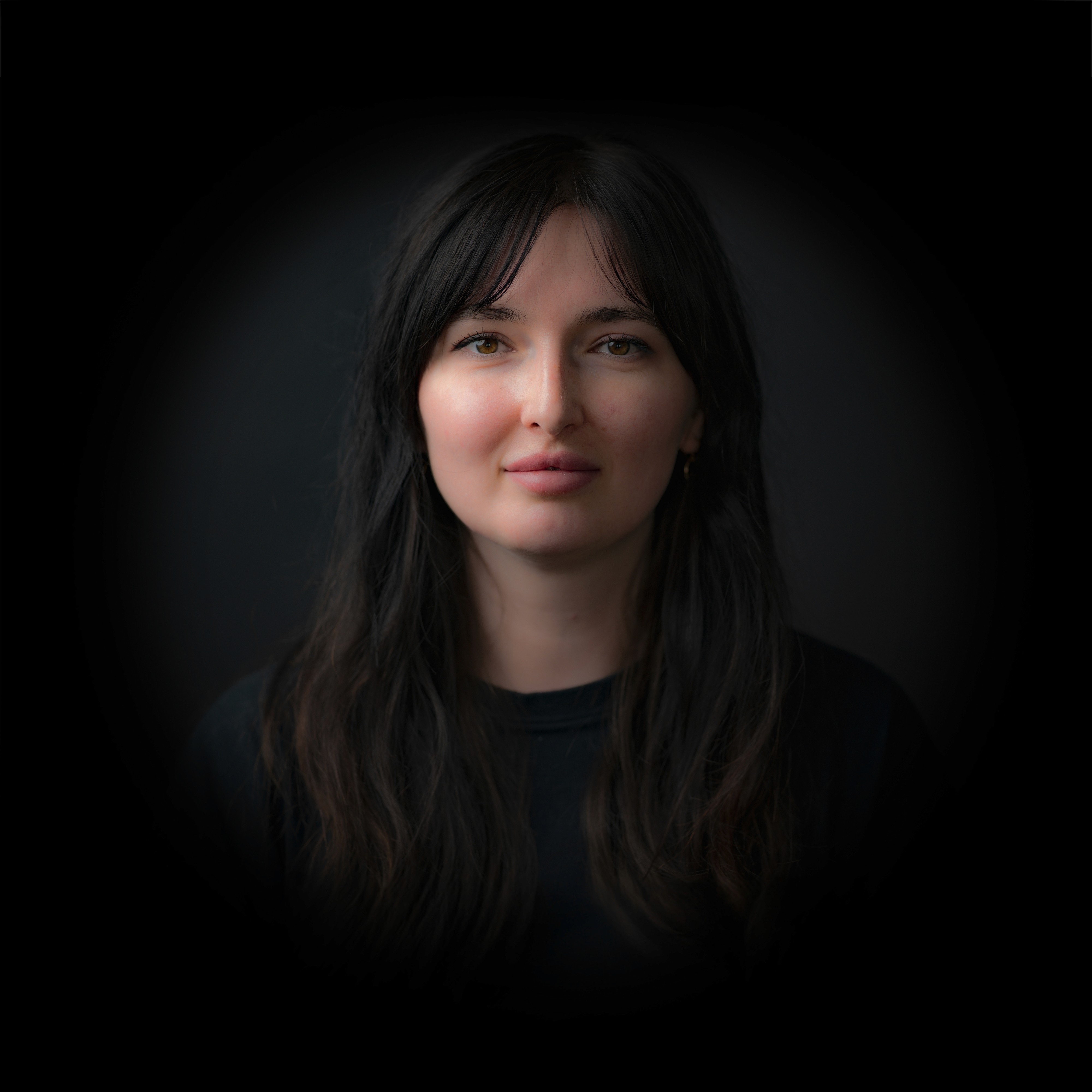 Portraitfotos von Daria Bilichuk mit dunklem Hintergrund.
